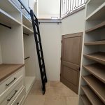 a clean walking closet with ladder