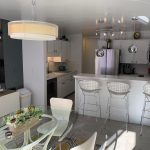 a clean dining area with a bar table in the kitchen