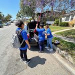 three woman packing up things after cleaning services